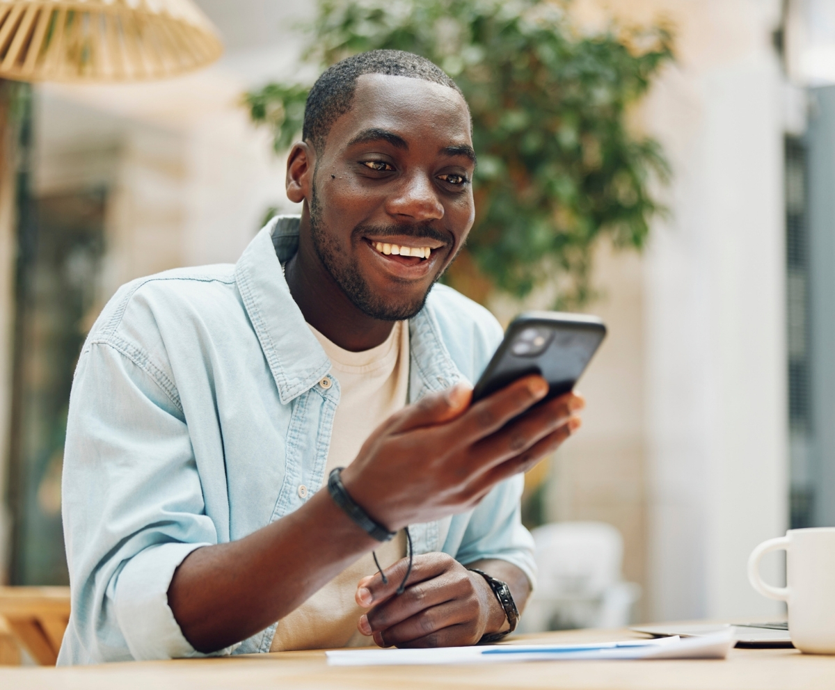 Man using a smartphone while reviewing balance transfer options