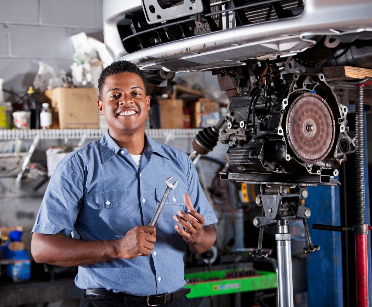 Mechanic holding a wrench beside a vehicle covered by Mechanical Breakdown Protection