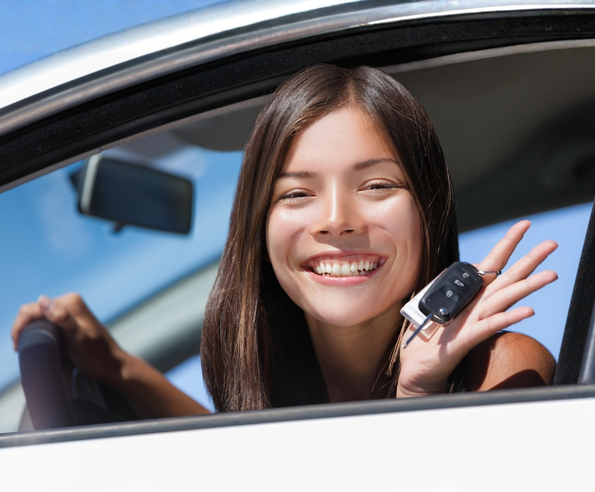 Smiling driver holding car keys after using auto buying services
