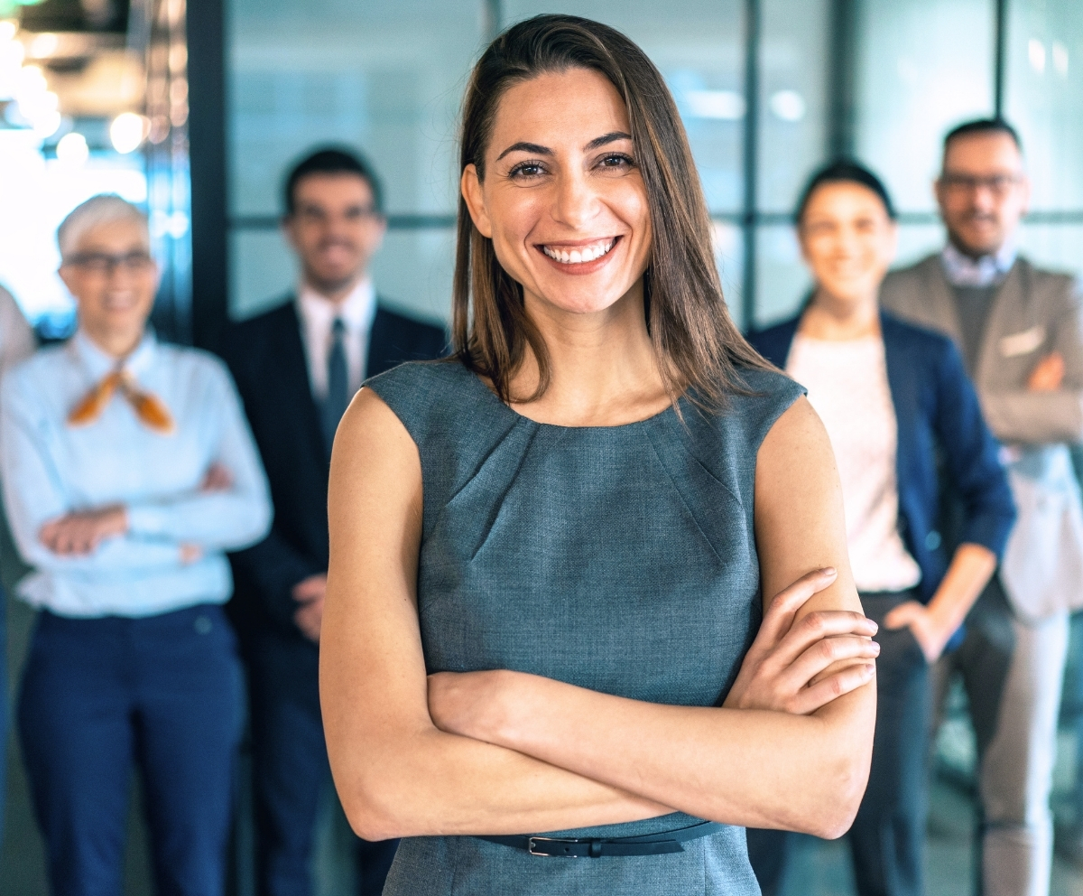Smiling professional standing with a business team representing Connect Credit Union member service