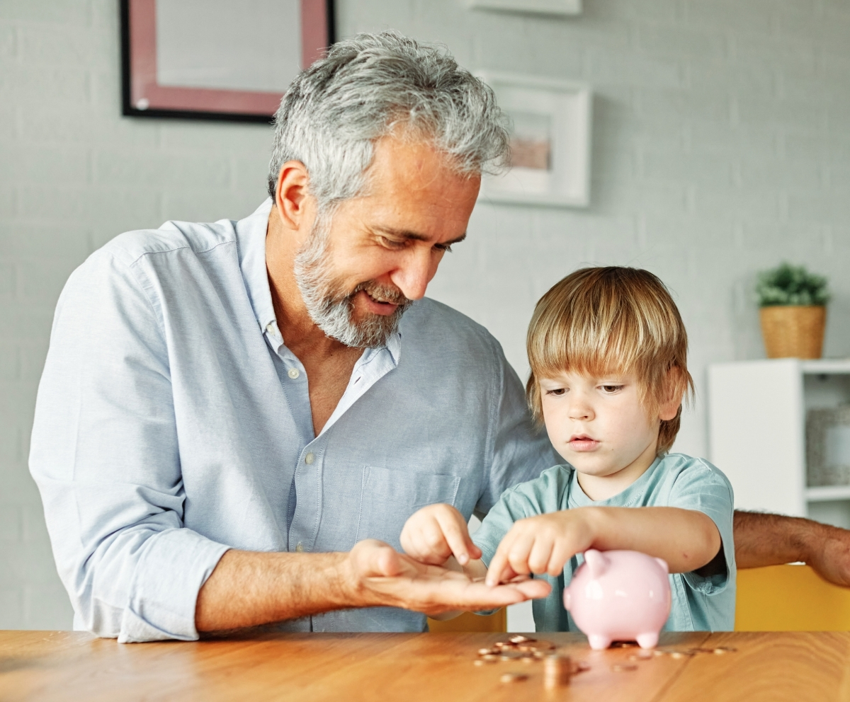 Grandparent helping a child save money with a piggy bank